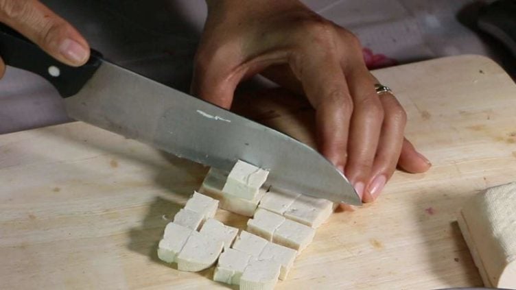 Photo showing tofu being cut into cubes for Shrimp Phat Thai