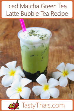 photo of iced Thai green tea with matcha latte with foam and dusted with match green tea powder