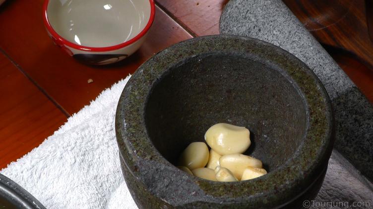 photo of garlic waiting to be crushed in the mortar and pestle 