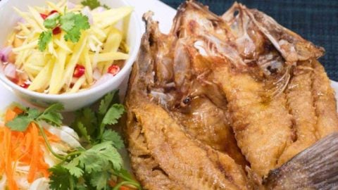Deep Fried Sea Bass with Mango Salad - Pla Krapong Tod Nam Pla photo of perfectly deep fried sea bass with sweet fish sauce and delicious mango salad