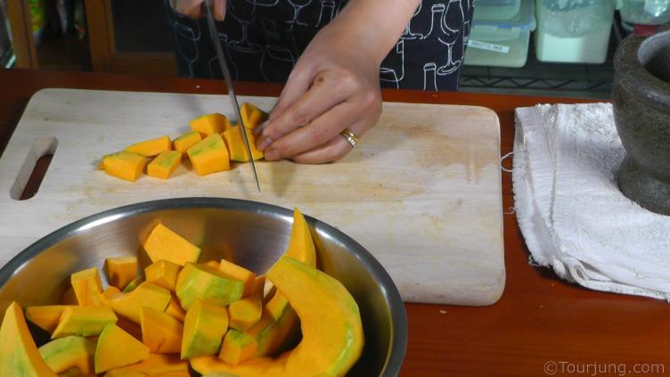 Thai Style Spicy Pumpkin Soup Recipe photo of chopping the pumkin into smaller pieces for the soup
