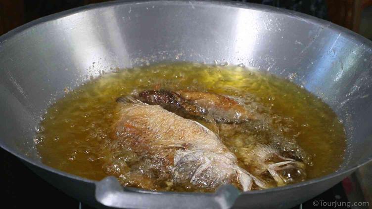 photo during teh deep frying of sea bass for tod nam pla recipe
