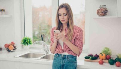 photo of woman using a mobile phone to search for recipe