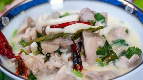 Easy & Authentic Tom Kha Gai Recipe - Thai Chicken Coconut Soup Photo of a delicious bowl of freshly made tom kha gai in a blue and gold bowl