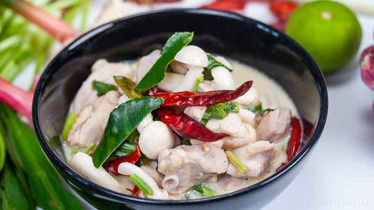 Easy & Authentic Tom Kha Gai Recipe - Thai Chicken Coconut Soup Photo of Tom Kha Gai in a black bowl for a different look