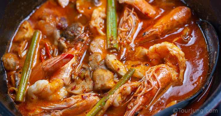 Easy Tom Yum Goong Recipe - Best Authentic Thai Hot & Sour Soup with Chili Paste (Nam Kon) Photo of red tom yum goong soup after chili paste added