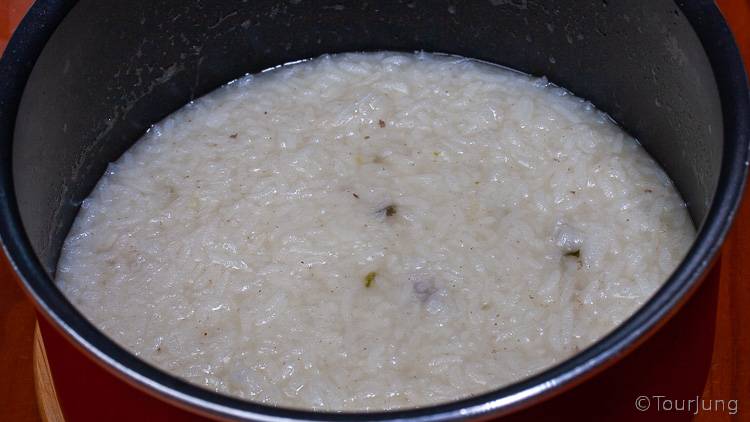 photo of rice in stock at beginning of the cooking process for chicken congee recipe