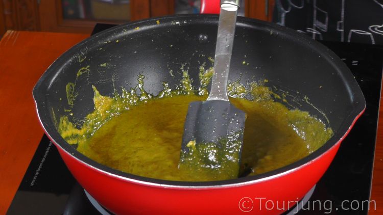 photo of green curry paste being stir-fried in cconut milk