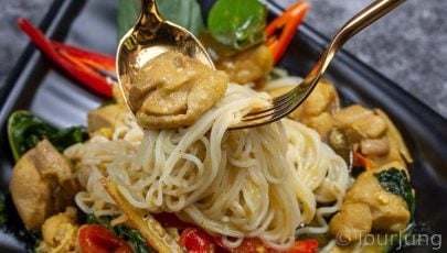 photo of Thai green curry with gold spoon and fork