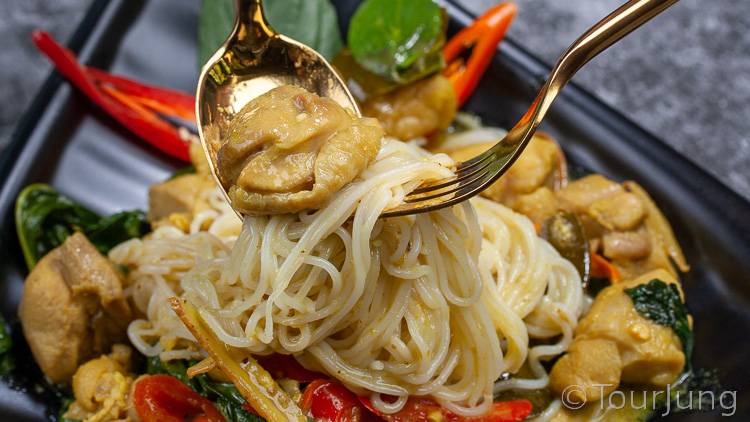 photo of Thai green curry with gold spoon and fork