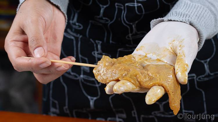 Awesome Thai Chicken Satay Skewers with Peanut Sauce Recipe - BBQ & Air Fryer Cooked Thai Street Food photo of placing chicken slices on teh wooden skewer