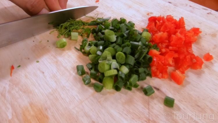 Photo of chopped green onion tops, kaffir lime leaf and chili for spicy cashew nut mix