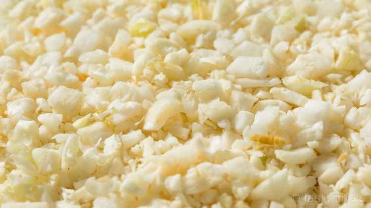 Cheesy Stir Fried Cauliflower Rice with Lemon Basil - Manual or with Processor Close up of raw cauliflower riced and ready for cooking