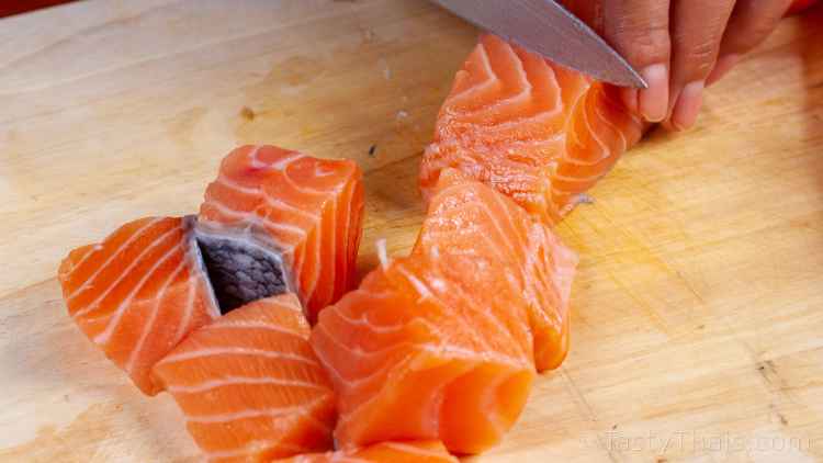 Best Authentic Thai Salmon Curry Recipe - Hor Mok Pla Salmon photo of cutting fresh salmon ingredient for Thai Red Curry