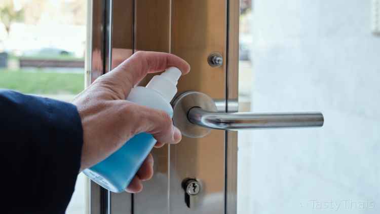 photo of residential door handle being disinfected to rid it of germs after use