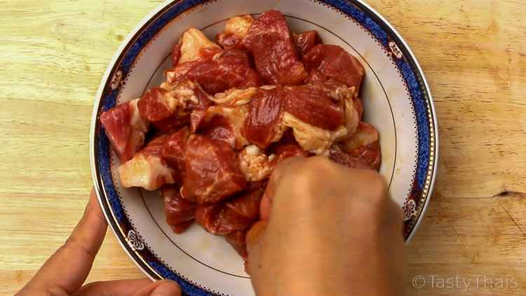 photo of pork shoulder cut into cubes and massaged with marinade