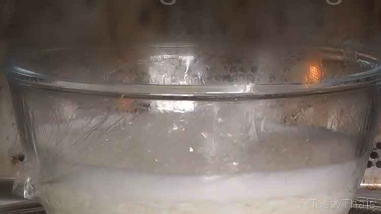 How to Cook The Best Microwave Rice in a Bowl - Thai Jasmine or White Rice photo of rice cooking in microwave with distended plastic wrap