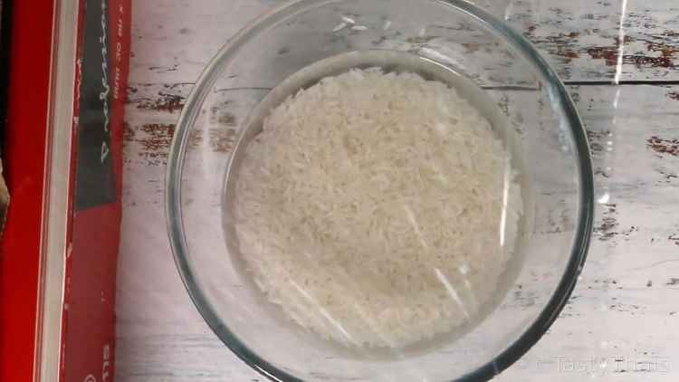 photo of covering the rice with plastic wrap to contain water and steam