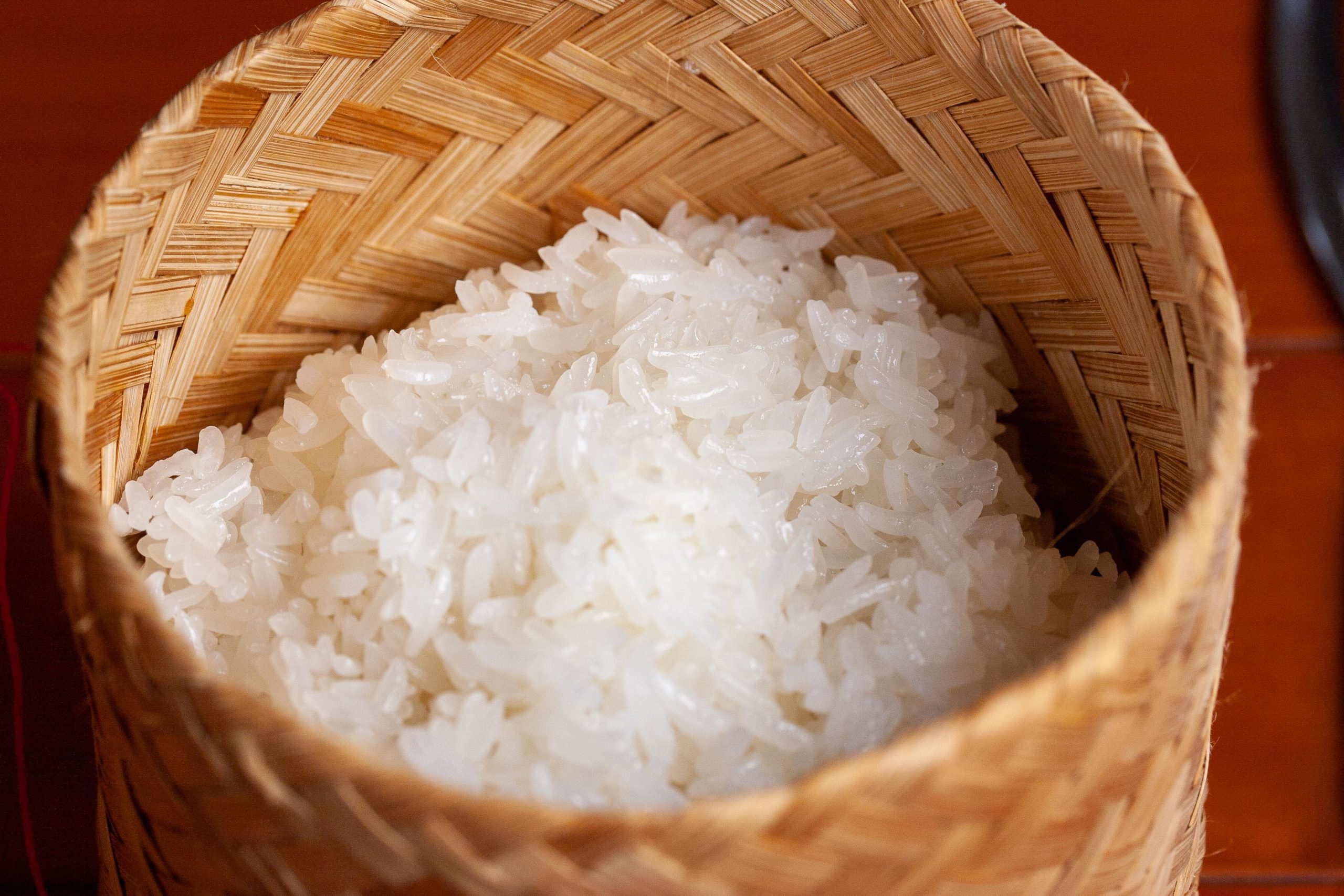 Hands cooking sticky rice with pot and rice steamer, traditional