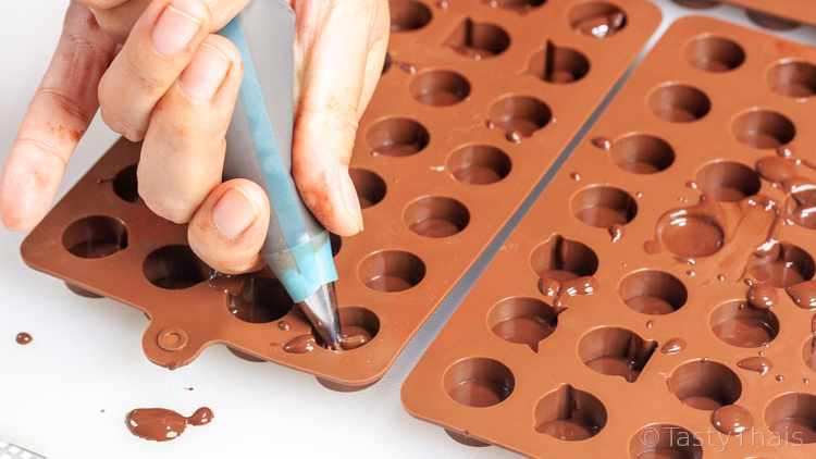 Homemade Emoji Chocolate Truffles - Family Fun Activity Adding the base layer of chocolate to the mold which makes the emoji face