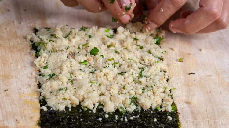 Layering out the cauliflower rice on the nori sheet for low carb sushi