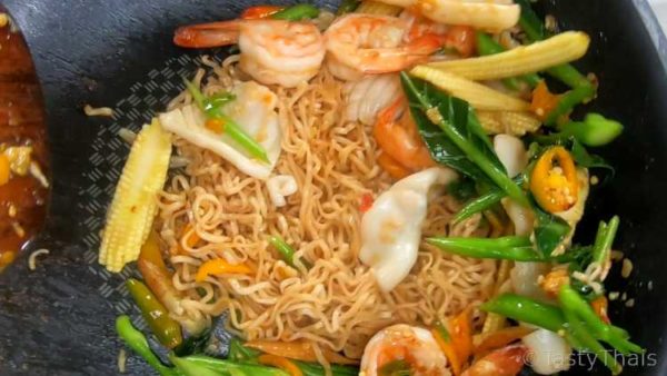 Add the noodles and seafood after stir frying the vegetables